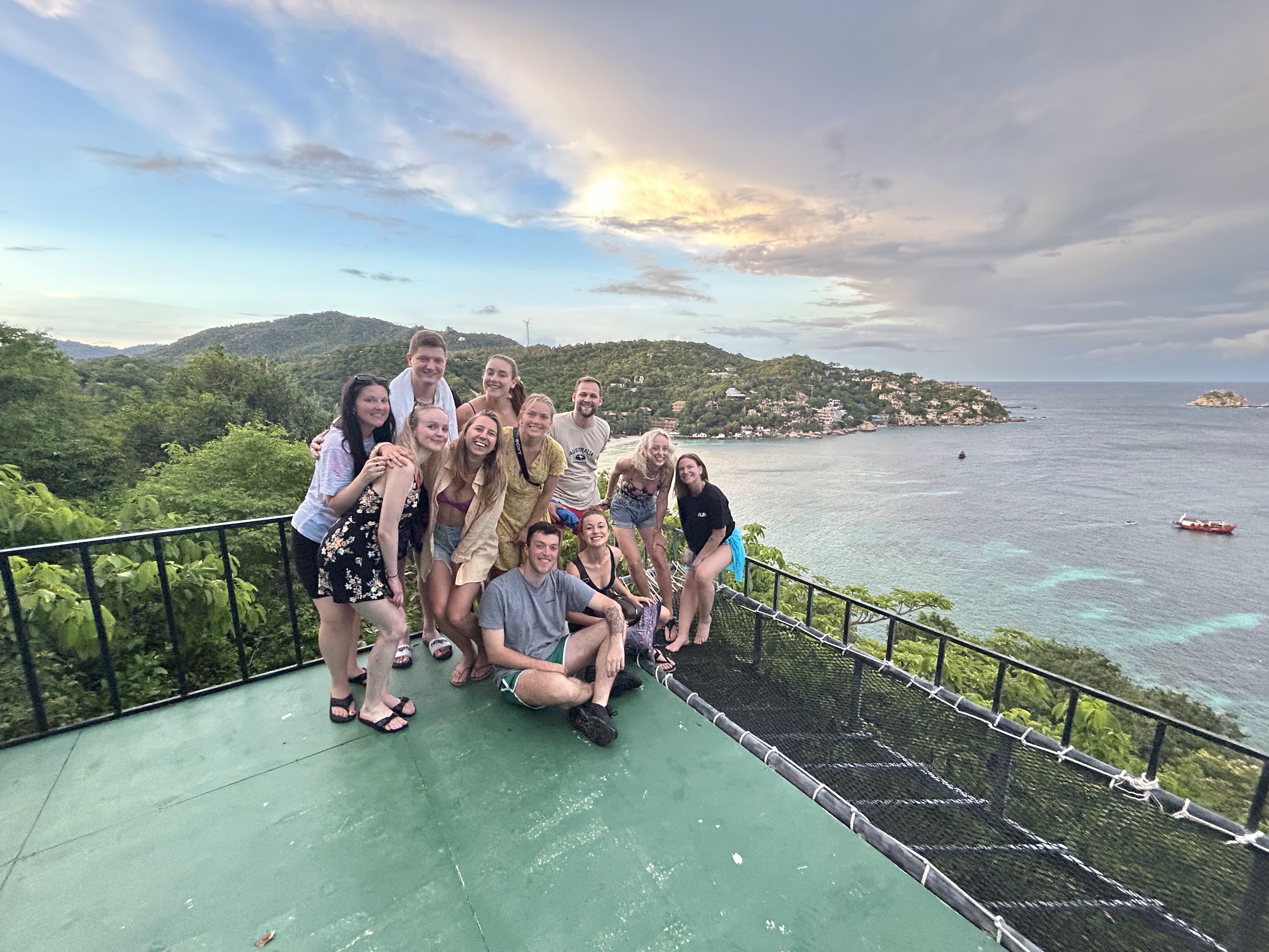 A group of travellers posing in front of a bay on Koh Tao island in Thailand - KILROY
