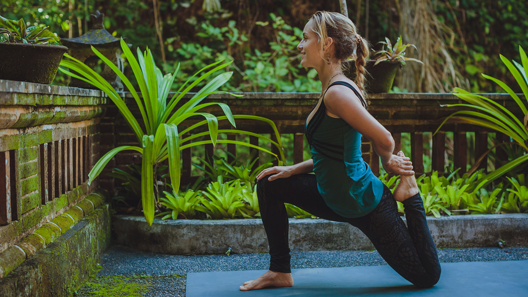 Image of a woman holding a yoga pose somewhere in Indonesia - KILROY