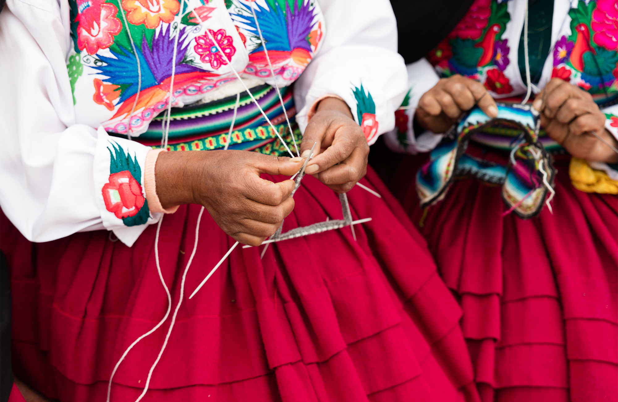 Image of Andean women wearing traditional blouses and colourful skirts in Peru - KILROY