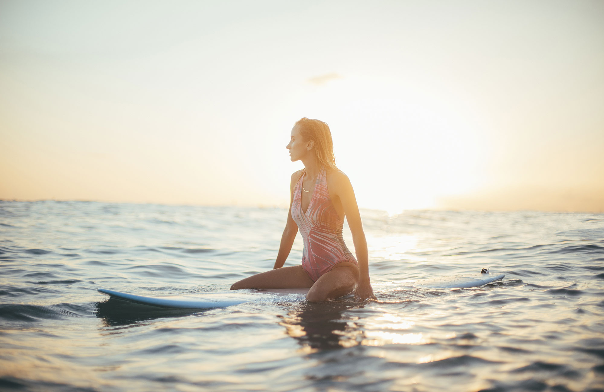 Image of a female surfer floating in the water -  KILROY