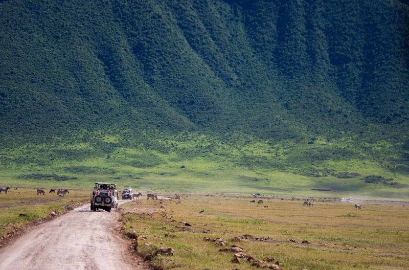 Image of safari trucks and wildlife in the Ngorongoro Crater in Tanzania - KILROY