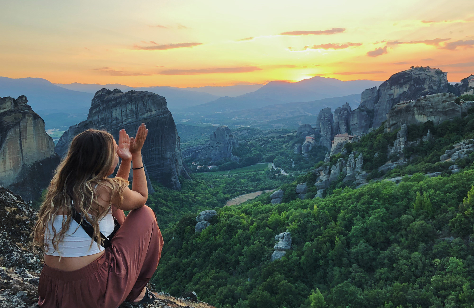 Image of a young female traveller overlooking Meteroa in Greece - KILROY