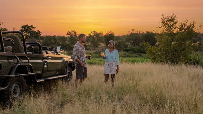 Image of a couple enjoying a sundowner while on safari in Kruger National Park in South Africa - KILROY