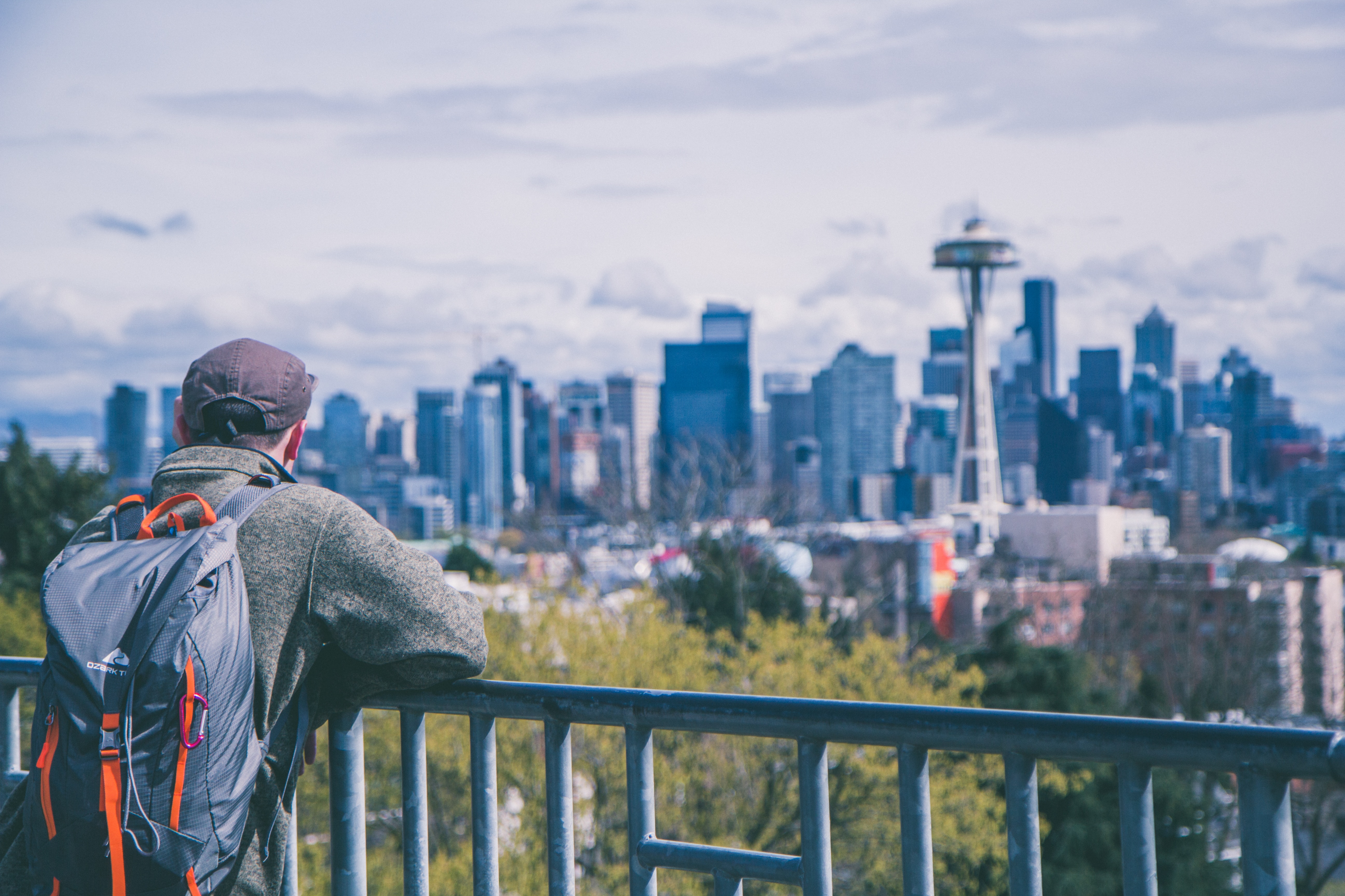 Image of a young male traveller looking out at the Seattle skyline in America - KILROY