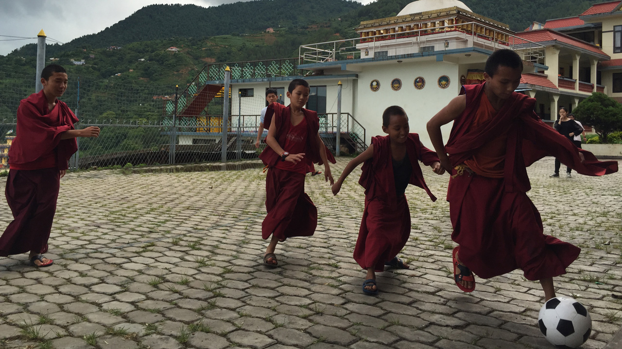 Image of young monks playing football at a monastery in Nepal - KILROY