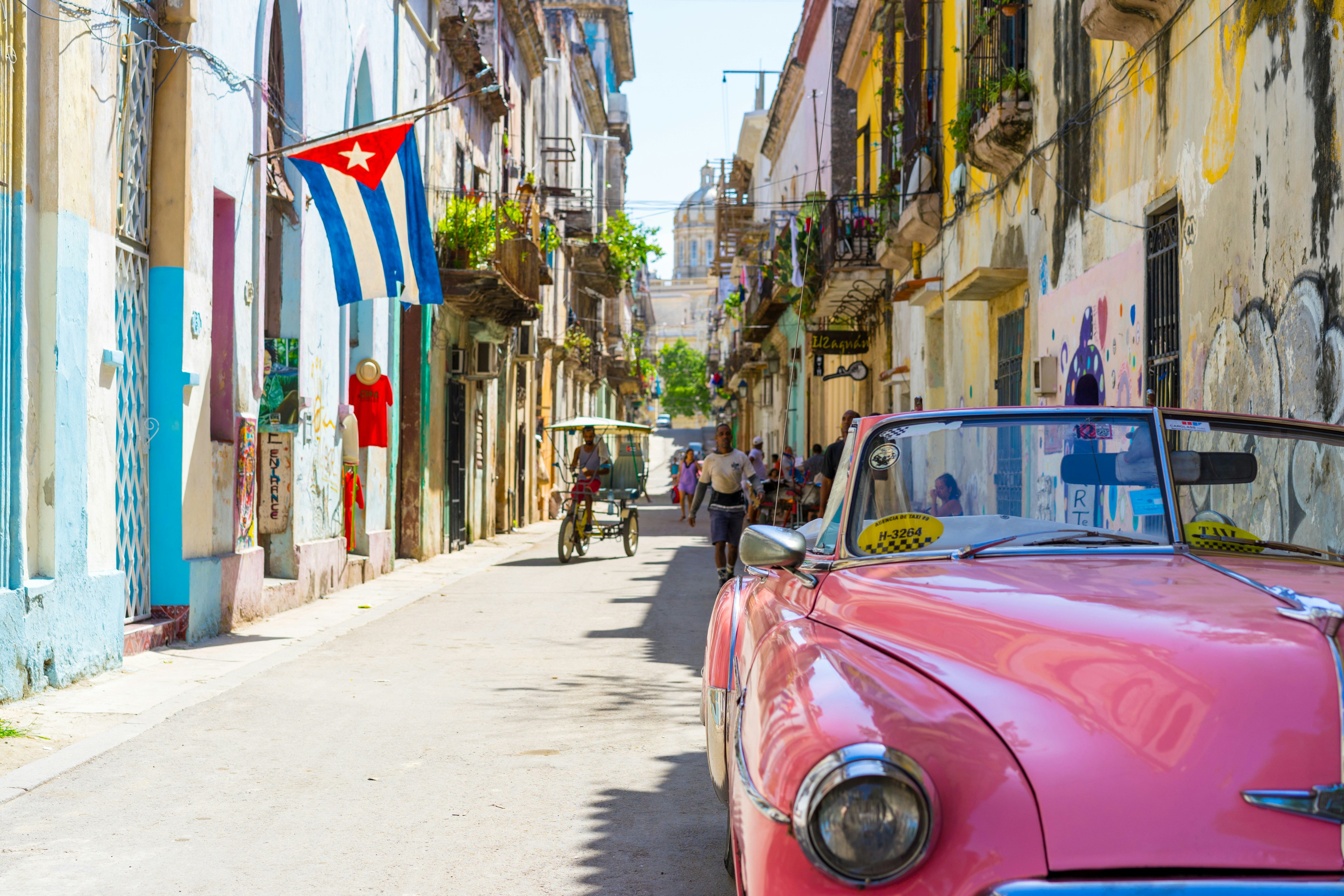 Image of a pink vintage car parked on a street in Havana, Cuba - KILROY