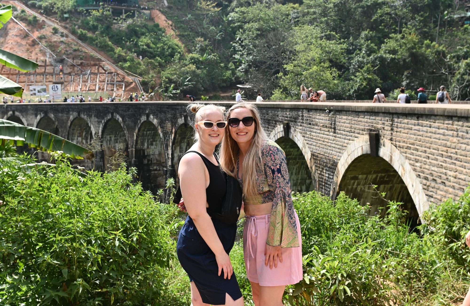 Image of young female travellers with views of a railway bridge in the tea region of Sri Lanka - KILROY
