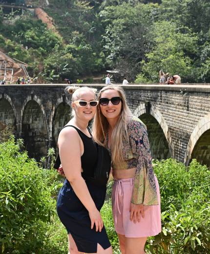Image of young female travellers with views of a railway bridge in the tea region of Sri Lanka - KILROY