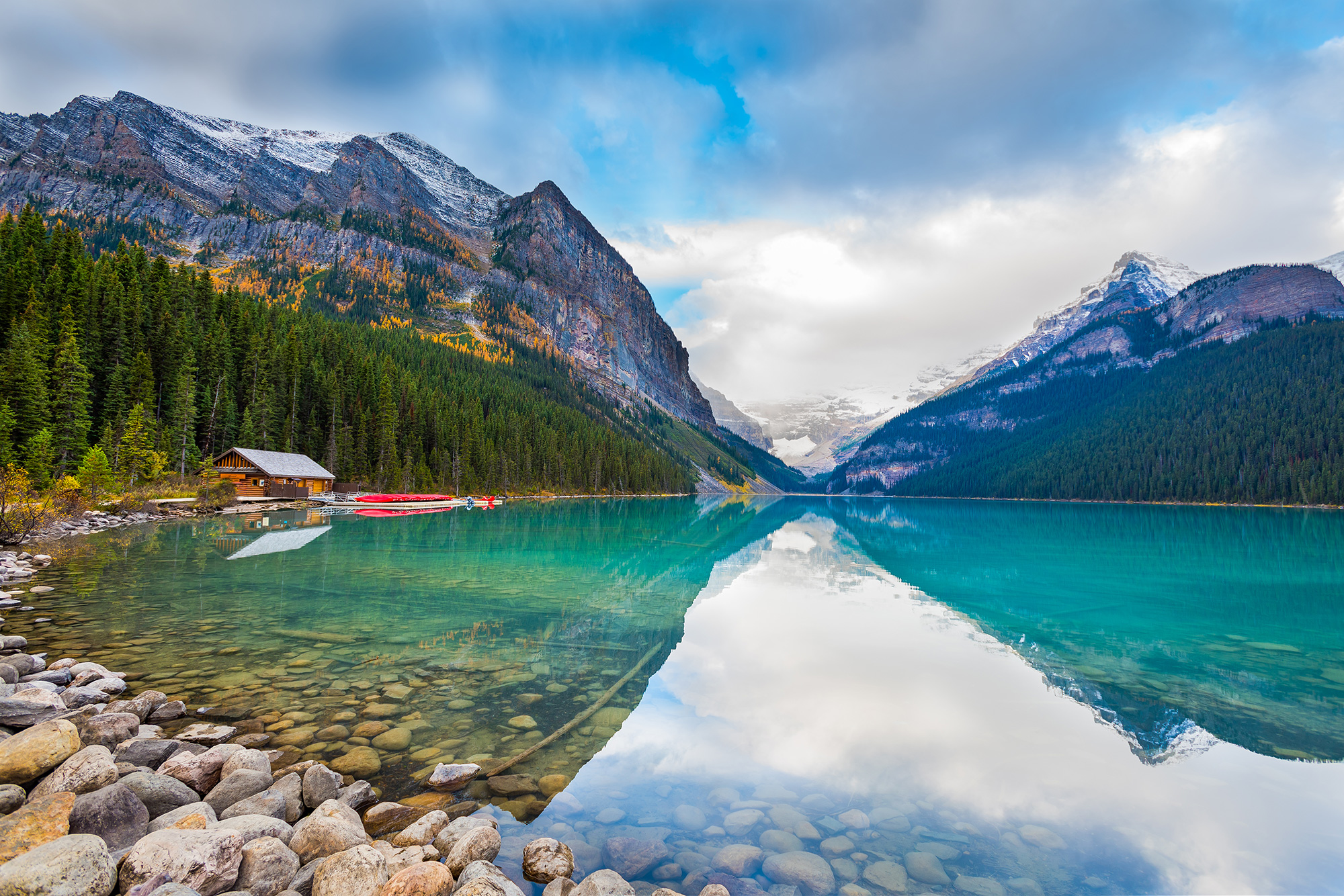 Crystal clear blue lake with snowy mountains in the background in Banff National Park in Canada