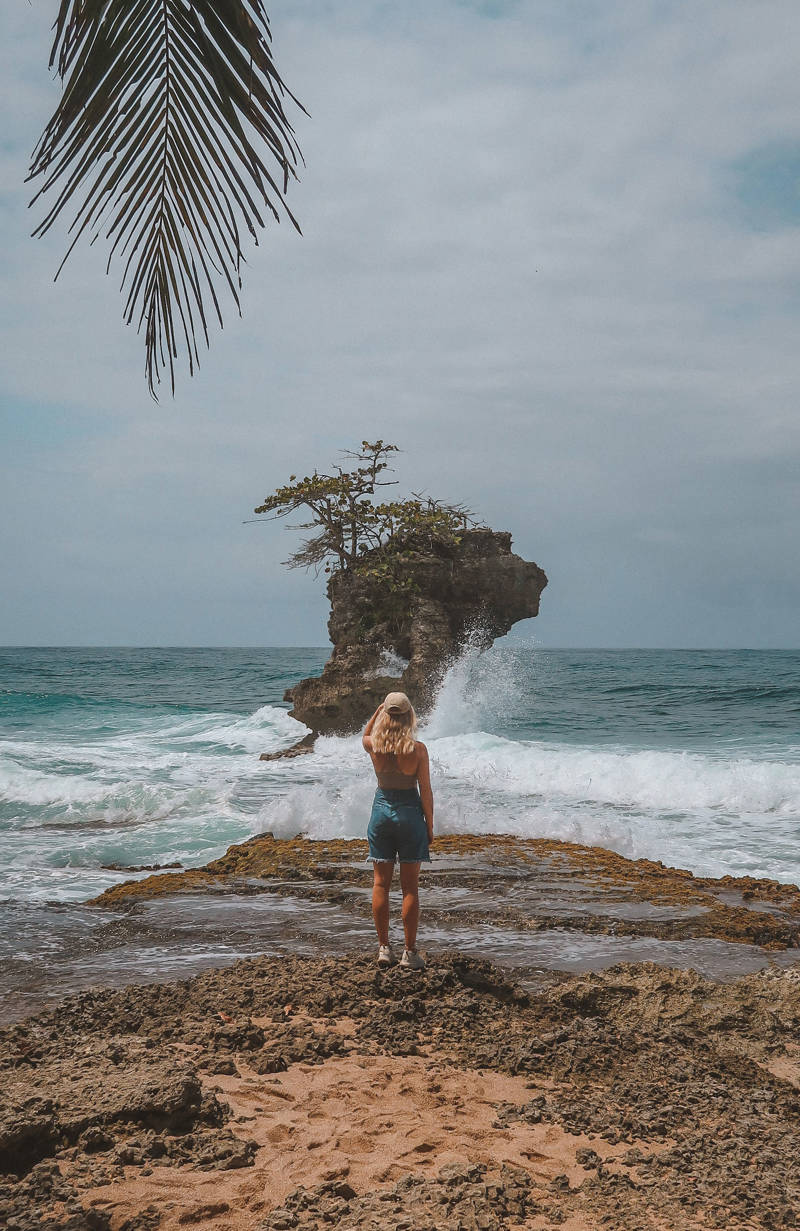 Girl looking out at a volcanic rock in Manzanillo, Costa Rica