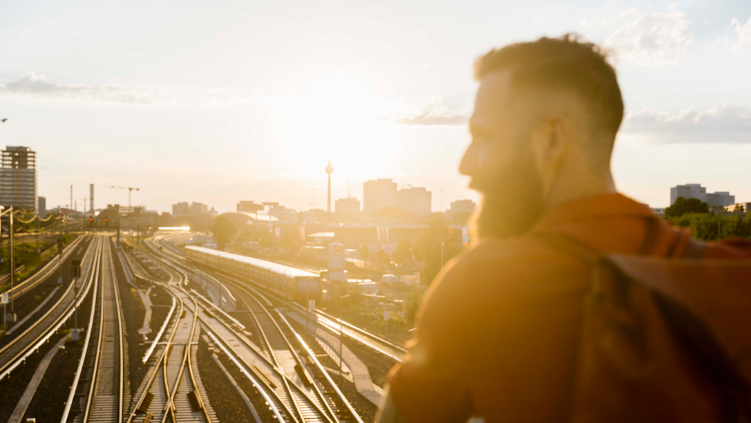 Image of a man looking out across a railway platform somewhere in Europe - KILROY