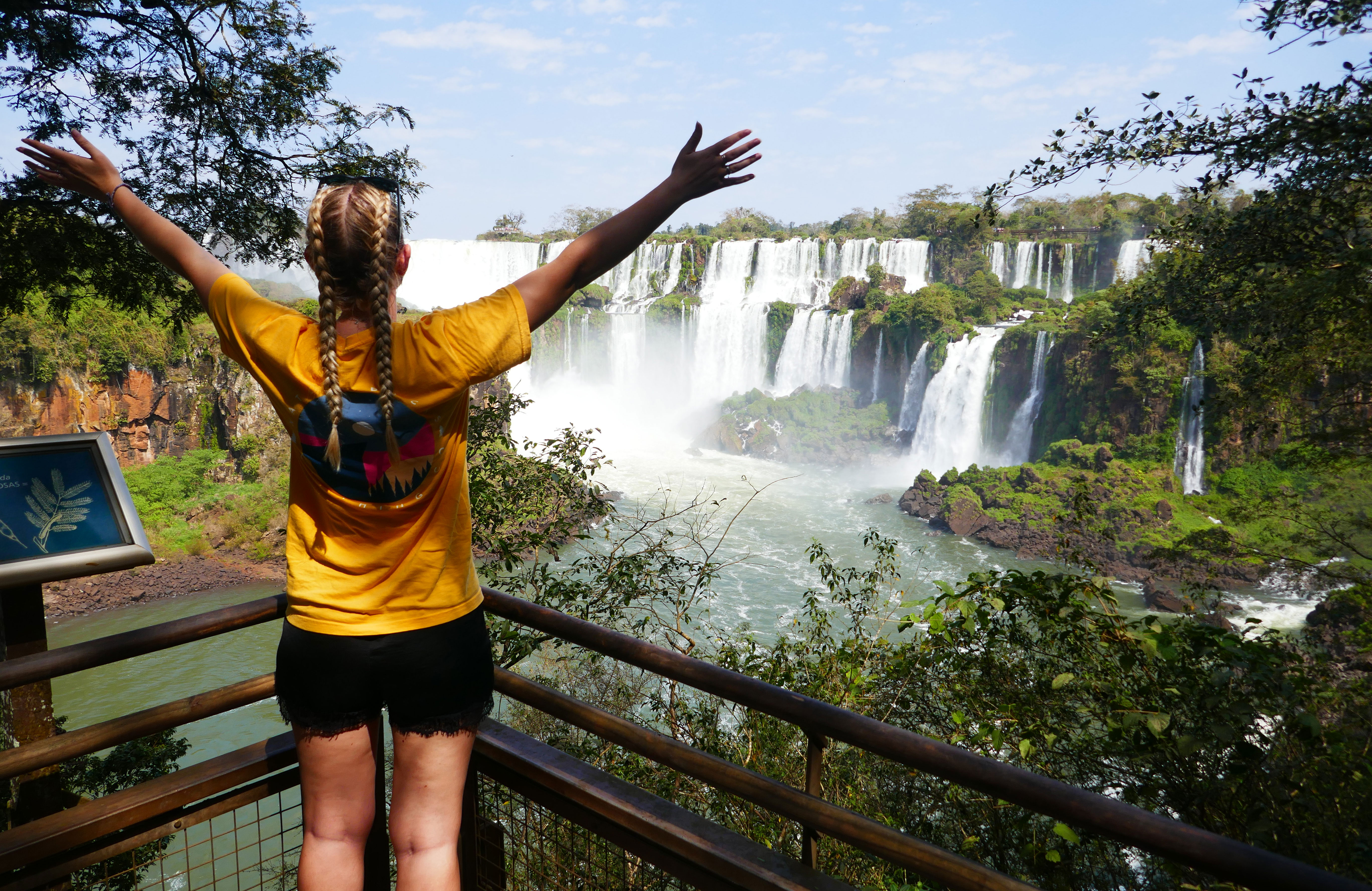 Image of a young female traveller looking towards Iguazu Falls in Brazil - KILROY