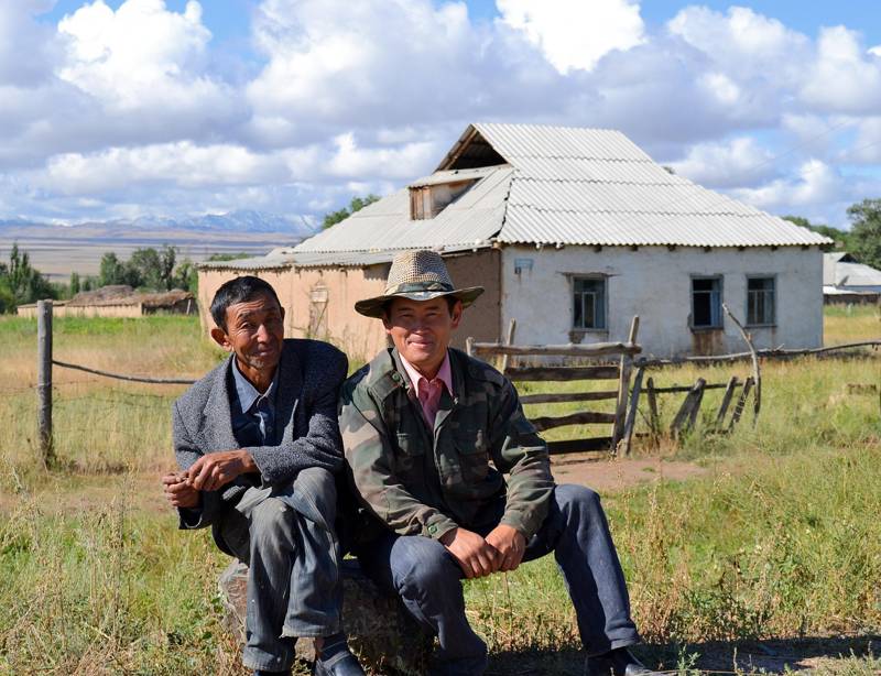 Image of two local men outside their house in Kyrgyzstan - KILROY