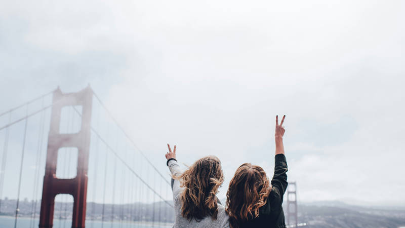 Image of two young female travellers near the Golden Gate Bridge in San Francisco