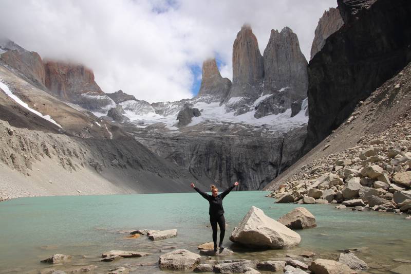 Image of a young female traveller in front of the Torres del Paine in Patagonia - KILROY