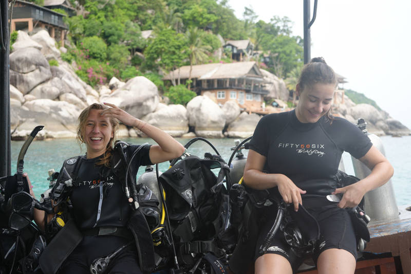 Image of two young women in scuba gear on a dive boat in Thailand - KILROY