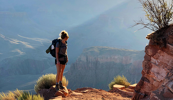 Girl Trekking With Backpack During Sunset