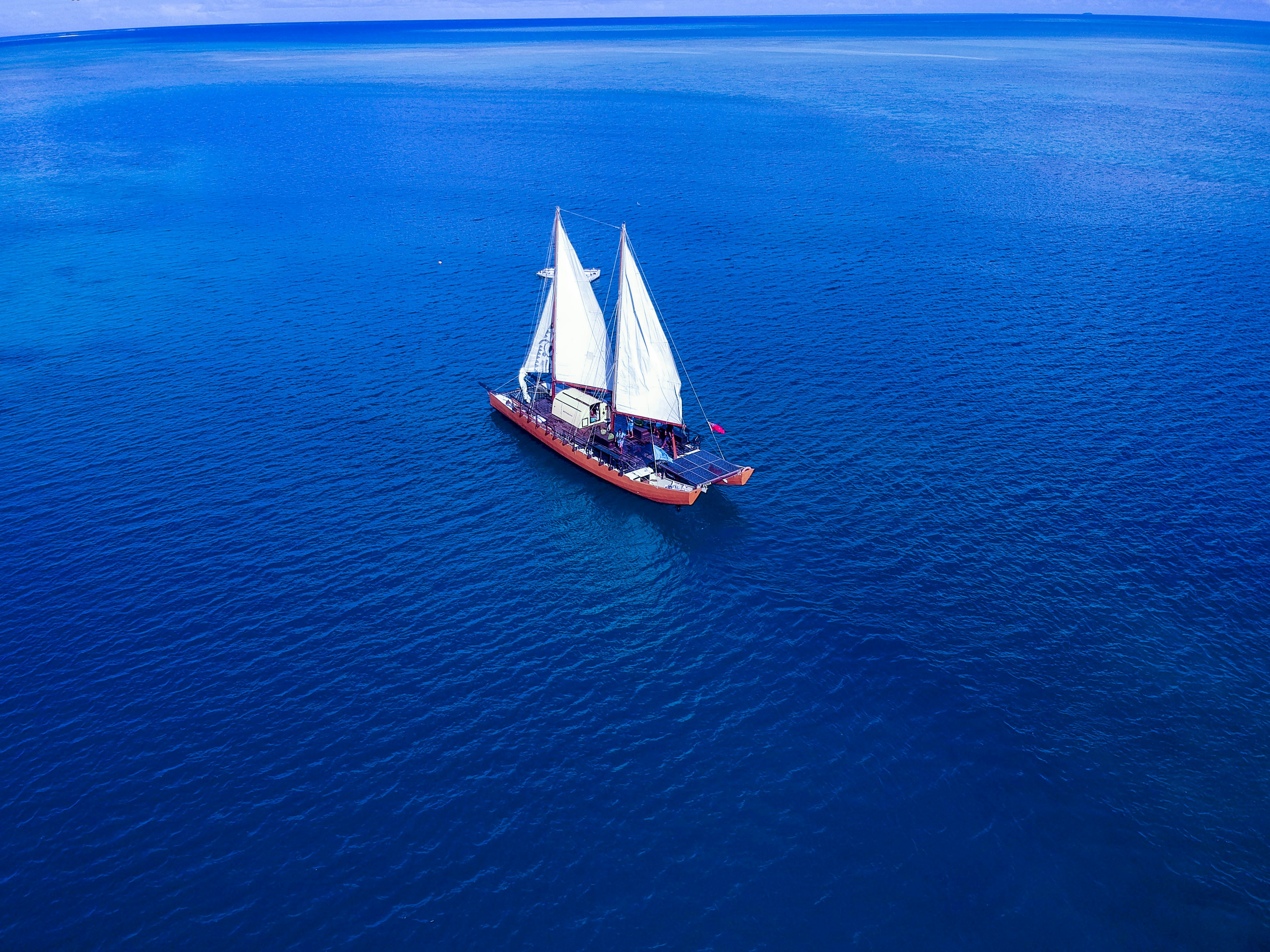 Image of a sail boat on vivid deep blue waters in Fiji - KILROY