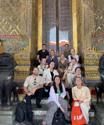 Image of a group of travellers in front of a temple in Bangkok - KILROY