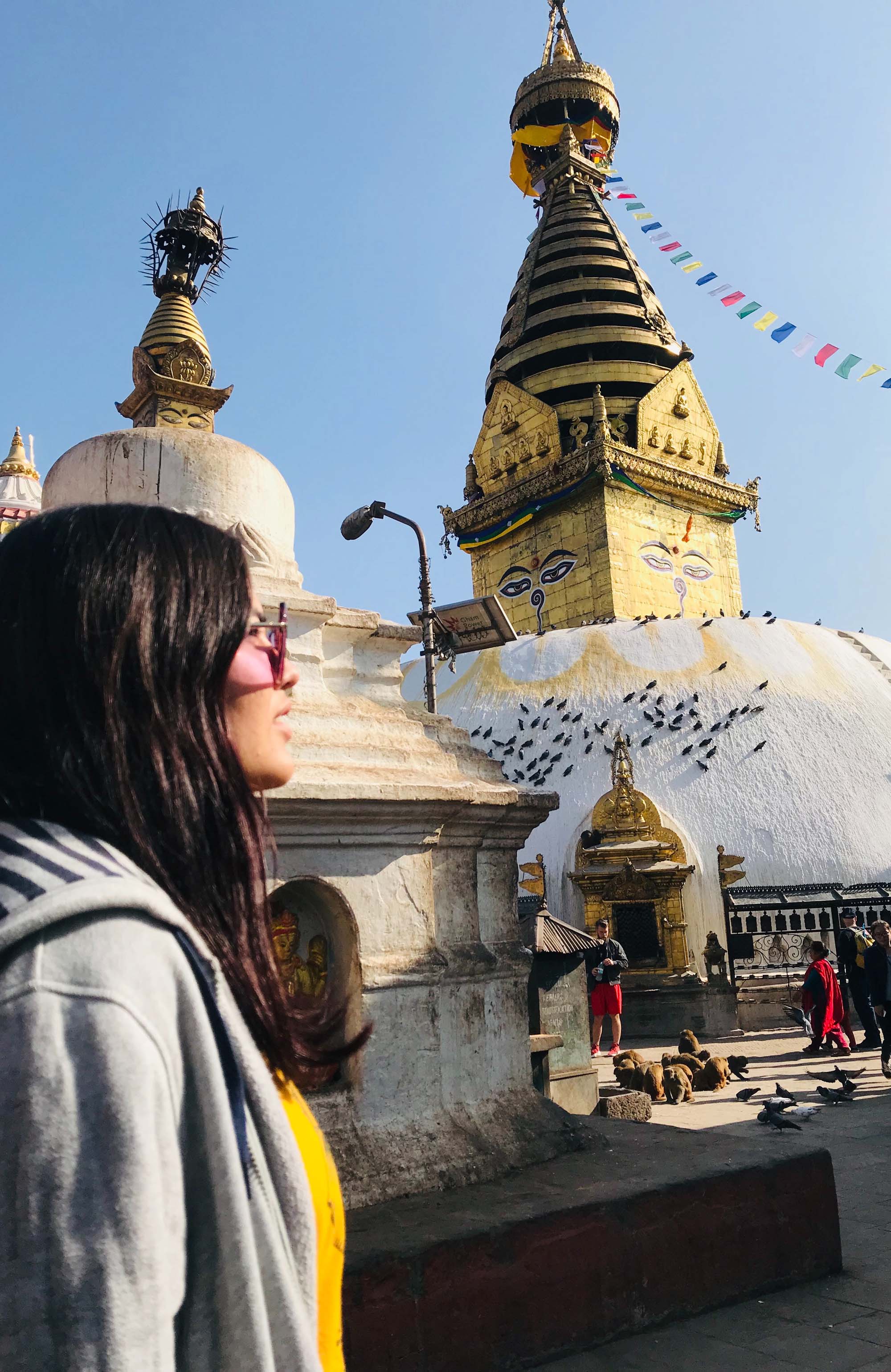 Image of a young female traveller in front of a temple in Kathmandu in Nepal - KILROY
