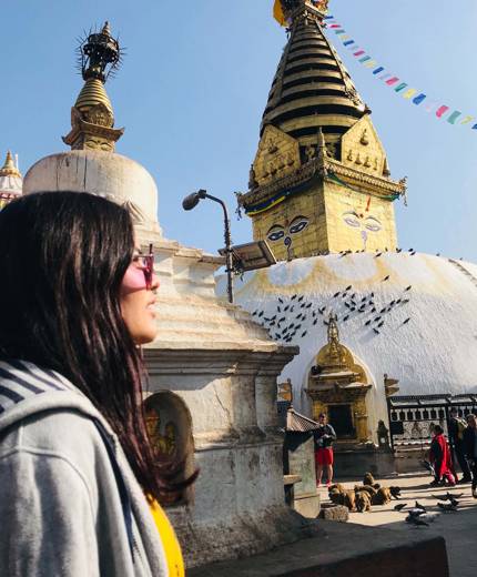 Image of a young female traveller in front of a temple in Kathmandu in Nepal - KILROY