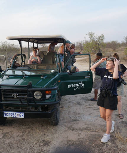 Image of a group of people near a safari truck in South Africa - KILROY