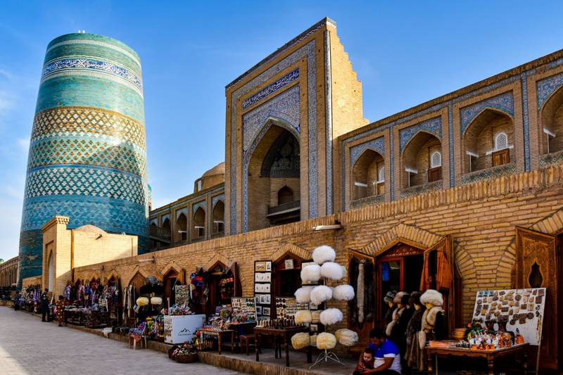 Image of shops lined up outside an old building in Uzbekistan - KILROY