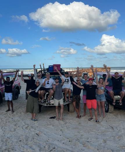 Image of a group of travellers posing in front of jeeps on K'gari island in Australia - KILROY