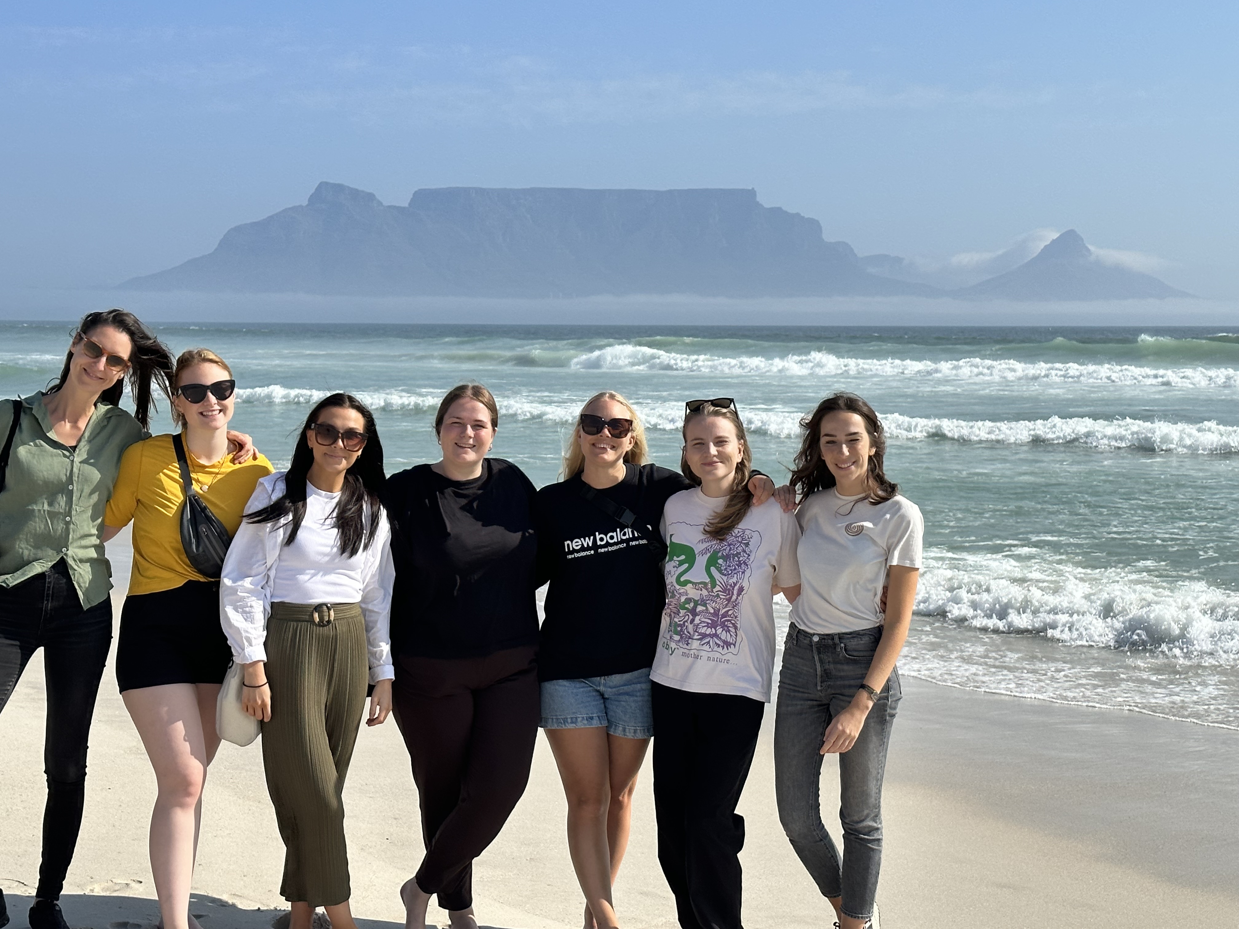 Image of a group of young female travellers posing in front of Table Mountain in Cape Town - KILROY