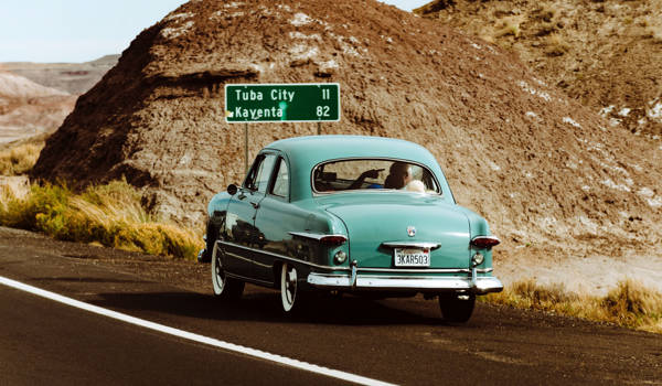 Lightblue Oldtimer Car By The Side Of The Road In A Desert Landscape In The USA