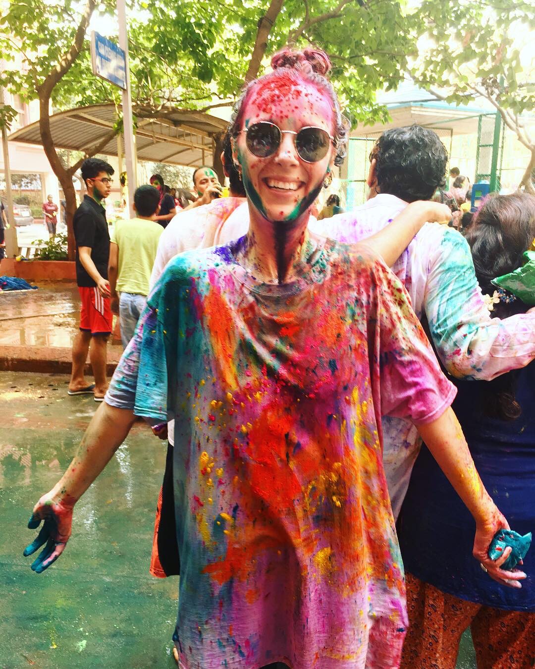 Image of a young female traveller covered in colourful paint at the Holi festival in India - KILROY