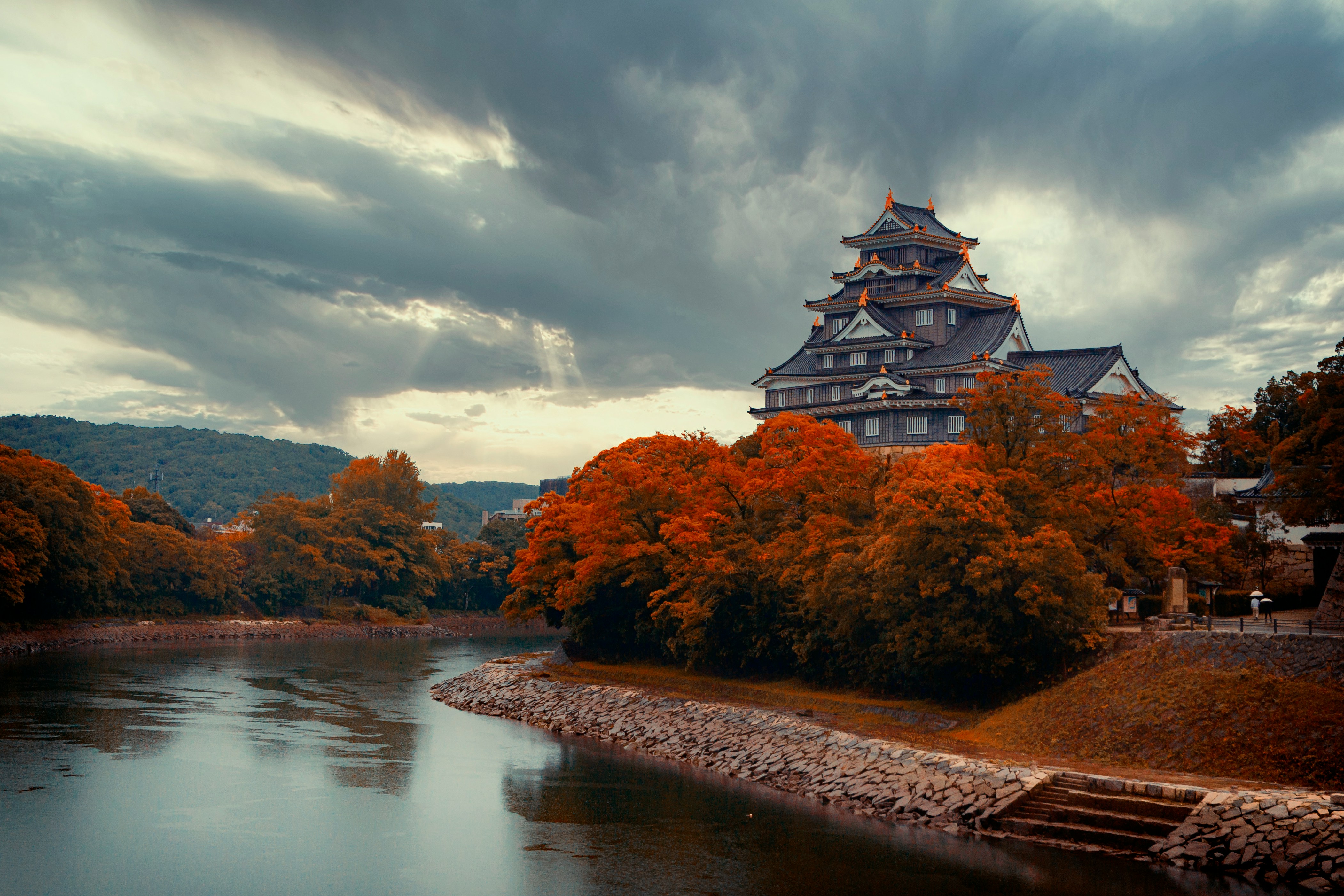 Image of a riverside castle with autumn colours on the trees in Japan - KILROY