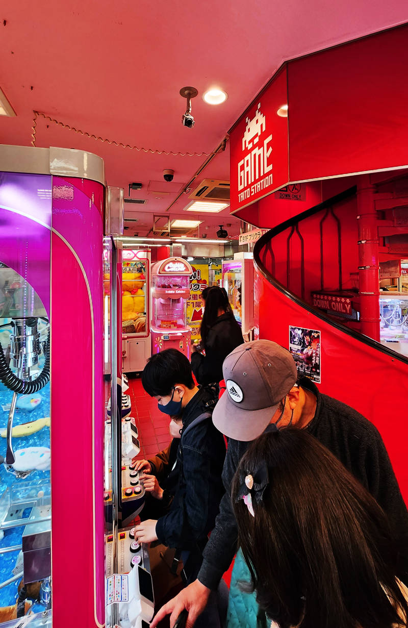 People playing inside a Taito Game Station in Tokyo, Japan