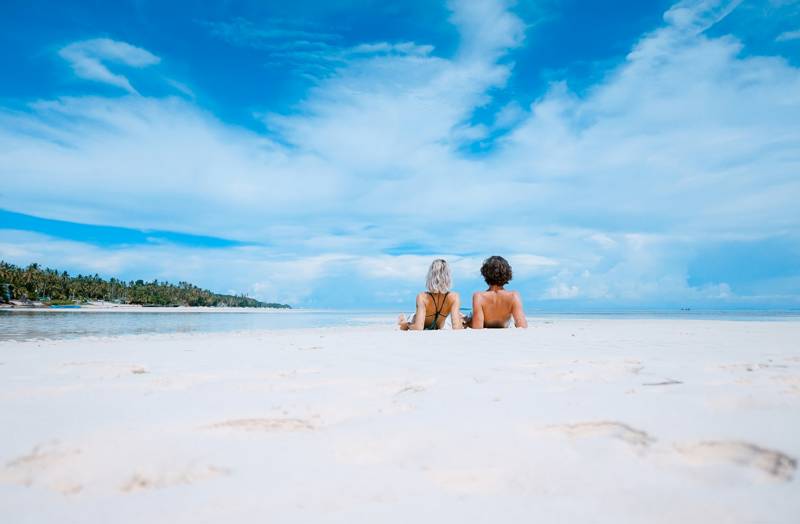 Image of a young couple relaxing on a tropical beach - KILROY