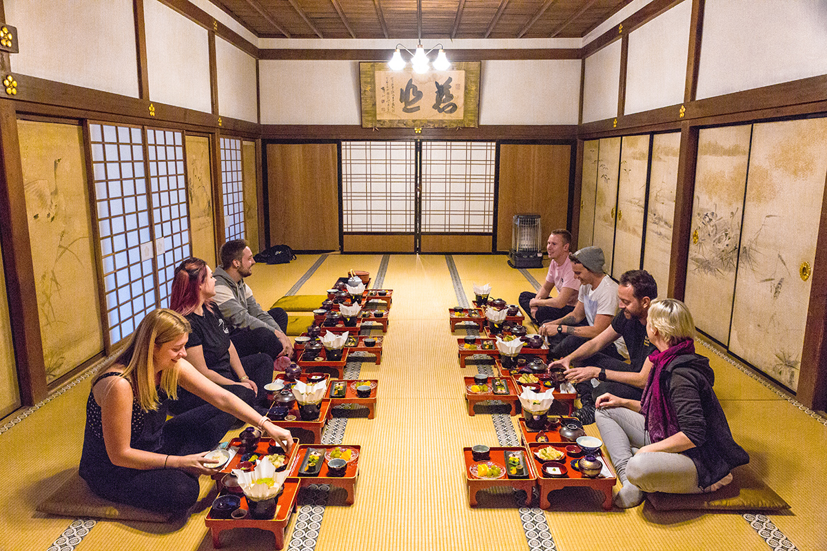 Image of a tour group at Koyasan temple with a traditional Japanese meal - KILROY