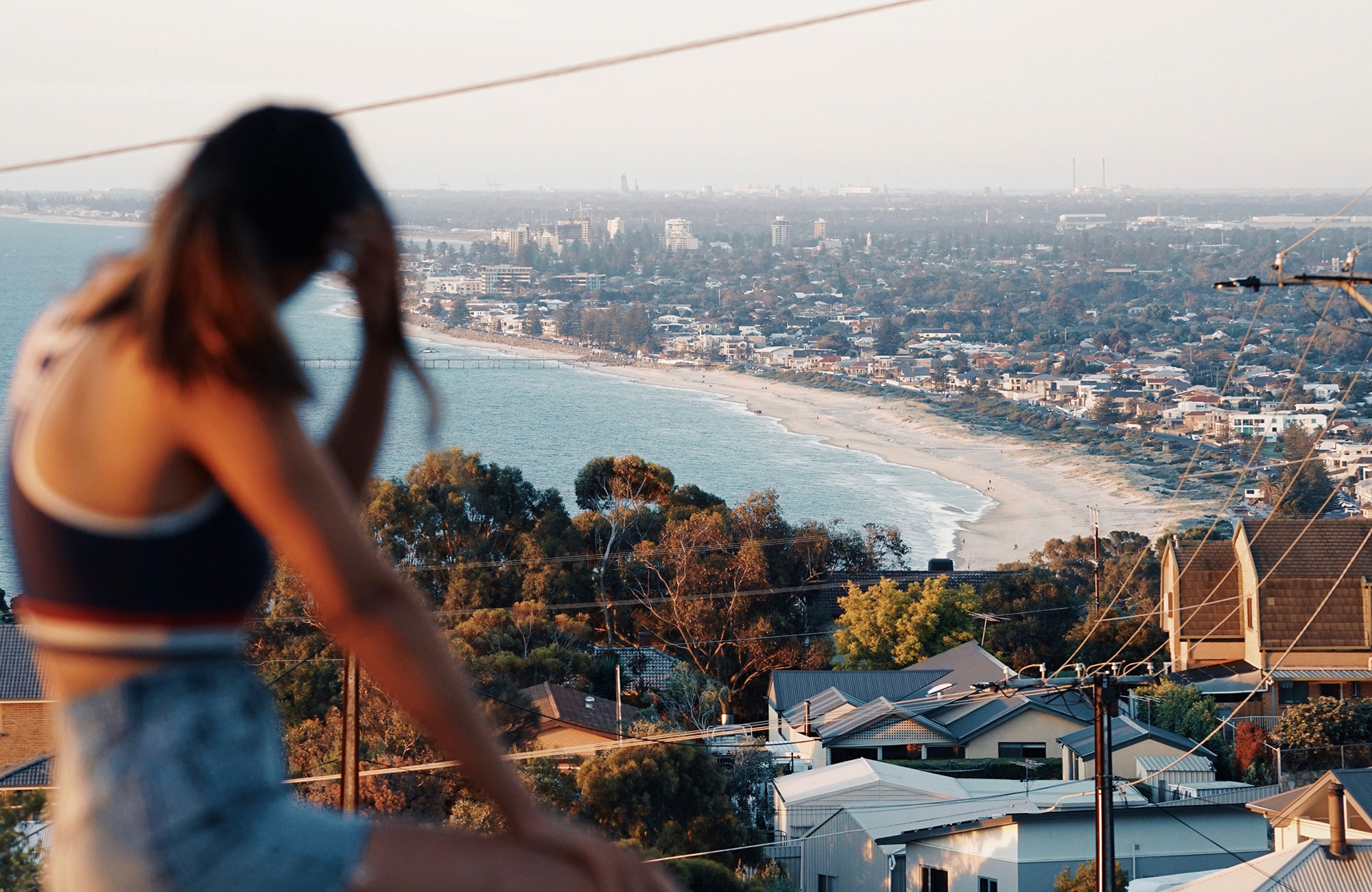 Image of a young female traveller overlooking a beach in Adelaide in Australia - KILROY